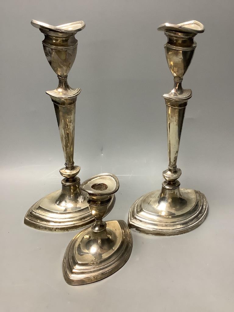 A pair of Mappin & Webb George III style silver candlesticks and a similar dwarf candlestick, H 30cm & 11cm